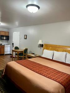 ein Hotelzimmer mit einem großen Bett und einer Küche in der Unterkunft Chief Motel in Keokuk