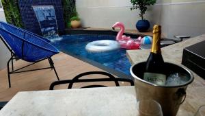 MOTEL COPACABANA في ريبيراو بريتو: زجاجة من النبيذ موضوعة على طاولة بجوار حمام السباحة