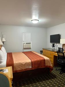 a hotel room with a bed and a desk at Chief Motel in Keokuk