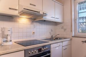 uma cozinha com um lavatório e um fogão forno superior em 50085... em Harlesiel