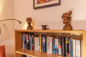 uma estante de livros com livros e dois bustos sobre ele em 50085... em Harlesiel
