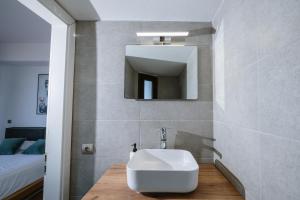 a bathroom with a sink and a mirror at Mare Apartment Costal Gem in Gázion +24 photos
