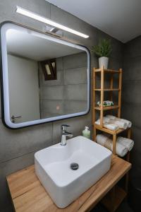 a bathroom with a white sink and a mirror at Mare Apartment Costal Gem in Gázion