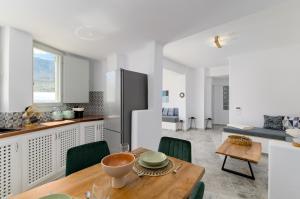 cocina y comedor con mesa de madera en Geminos Complex Villas, en Kamari