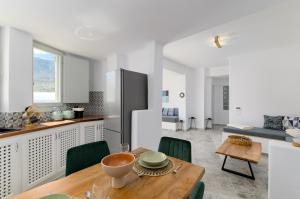 una cucina e una sala da pranzo con tavolo in legno di Geminos Complex Villas a Kamari