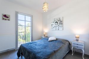 a bedroom with a blue bed and a window at Plein centre ville Biscarrosse bourg appartement 2 chambres dans résidence in Biscarrosse
