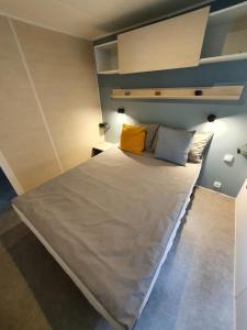a bedroom with a large bed with two pillows at Campingland Ostsee - Mobilheim A1Seestern in Schashagen