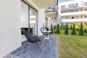 patio con mesa y sillas en el balcón en Gdynia Nasypowa Apartments with Parking by Renters, en Gdynia