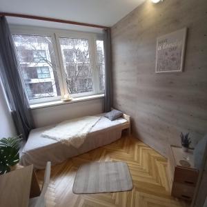 a bedroom with a bed and a window at Regem Pokoje Złota in Warsaw