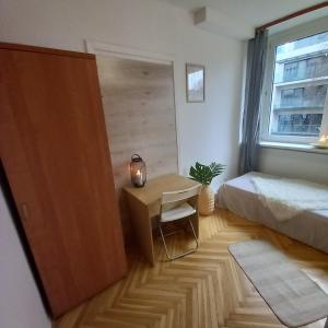 a bedroom with a bed and a desk and a window at Regem Pokoje Złota in Warsaw