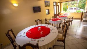 - une salle à manger avec 2 tables et un chiffon rouge dans l'établissement Hotel Windsor-Mombasa, à Mombasa