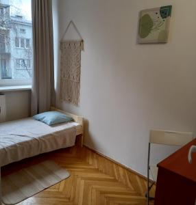 a small bedroom with a bed and a window at Regem Pokoje Złota in Warsaw