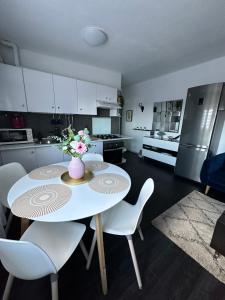 a kitchen with a table with chairs and a vase with flowers at Apartamento acogedor en la laguna in Las Lagunas