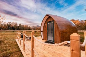a circular wooden building on a deck with a fence at The Secret Hideaway in Penicuik