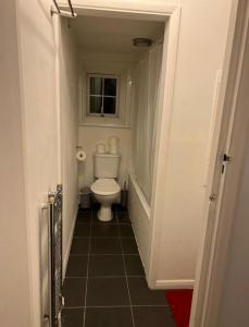 a small bathroom with a toilet and a window at Wembley Park Studios in London