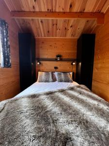 a bedroom with a large bed with wooden walls at Lodge on the campsite in Oostvoorne