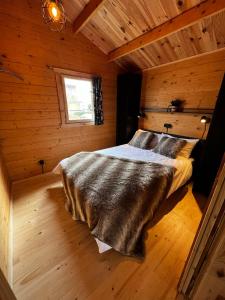 een slaapkamer met een bed in een houten hut bij Lodge on the campsite in Oostvoorne