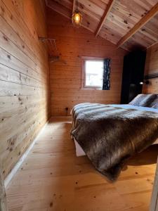 una camera da letto con letto in una camera in legno di Lodge on the campsite a Oostvoorne