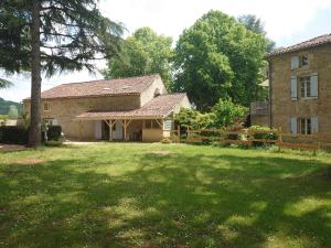 una casa con un gran patio delante de ella en Gîte La Buissière Duravel piscine couverte privative en Duravel