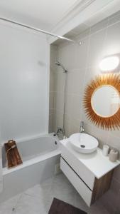 La salle de bains est pourvue d'un lavabo, d'une baignoire et d'un miroir. dans l'établissement Ria Mar Fuzeta Apartments, à Fuzeta