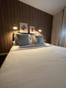 ein Schlafzimmer mit einem großen weißen Bett mit zwei Kissen in der Unterkunft Apartamento acogedor en la laguna in La Laguna