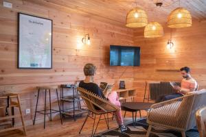 zwei Personen sitzen auf Stühlen in einem Raum mit Holzwänden in der Unterkunft Huttopia Pays de Cordes sur Ciel in Albi