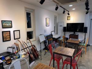 a room with tables and chairs and a flat screen tv at Haru The Guesthouse in Andong