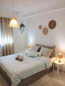 um quarto com uma cama com dois chinelos em Ria Mar Fuzeta Apartments na Fuzeta