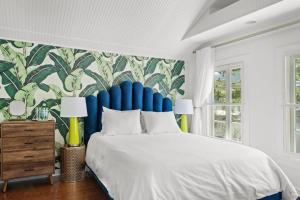 a bedroom with a large bed with a blue headboard at The Julia Place Carriage House in Sarasota