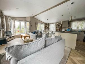 ein Wohnzimmer mit einem Sofa und einer Küche in der Unterkunft Beautiful Lodge With Decking At Azure Seas In Suffolk, Sleeps 6 Ref 32217og in Lowestoft