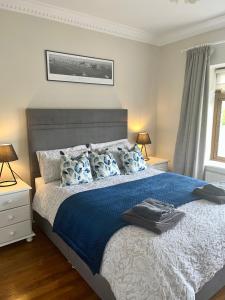 1 dormitorio con 1 cama grande con sábanas y almohadas azules en Carraig House, en Cavan