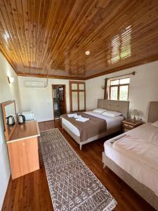 a bedroom with two beds and a wooden ceiling at Kekova Pansiyon in Demre