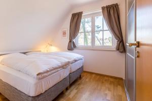 a bedroom with a bed and a window at Strandleben 10 - Louis Douzette in Ahrenshoop +18 photos