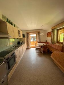 eine Küche mit einem Tisch und einem Esszimmer in der Unterkunft Ferienwohnung Zillertaler Alpenblick in Zell am Ziller