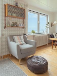 - un salon avec un fauteuil et un pouf dans l'établissement Serenity by the Sea / 3-BR House / Sea View, à Syðrugøta