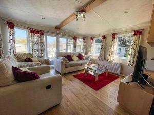 a living room with a couch and a tv at 6 Berth Caravan With Decking At Cherry Tree Park In Norfolk Ref 70014g in Great Yarmouth