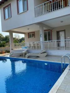 una piscina frente a una casa en Doğanın kalbinde havuzlu villa, en Koycegiz