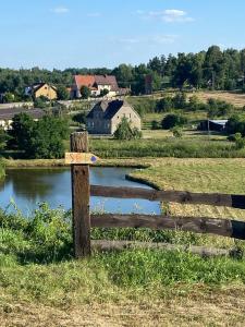 drewniany płot na polu obok stawu w obiekcie Jeleńczówka Alte Dorfschule w mieście Parchowo