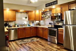 a kitchen with wooden cabinets and stainless steel appliances at Browning Lambert Resort - Hatfield McCoy and Local Off-Road Trails in Rock