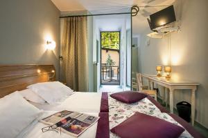 una habitación de hotel con una cama con una revista. en Logis Hôtel Restaurant Le Mont Aigoual en Meyrueis