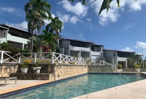 a hotel with a swimming pool in front of a building at Cozy apartment with beach at walking distance and pool in Dickenson Bay