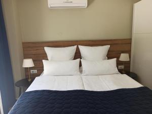 a bedroom with a large bed with white sheets and pillows at AdriaApart in Sveti Filip i Jakov