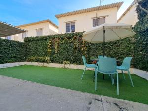 stół i dwa krzesła z parasolem na trawniku w obiekcie Casa Vacacional en Conjunto Privado w mieście Manta