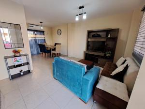 sala de estar con sofá azul y mesa en Casa Vacacional en Conjunto Privado, en Manta