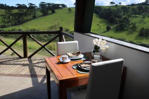 a table and chairs with a table and a window at Estalagem Sensações in Cunha