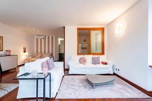 ein Wohnzimmer mit 2 weißen Sofas und einem Tisch in der Unterkunft Cavour 9 in Rapallo