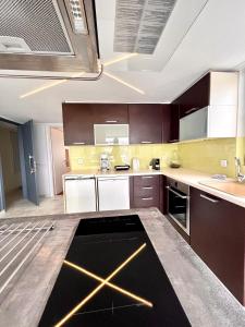 a kitchen with brown cabinets and a counter top at CityCenter Penthouse mini Private Pool with Hydromassage and Great Town View in Athens