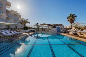 uma piscina num hotel com cadeiras e guarda-sóis em Herbert Samuel The Reef Eilat em Eilat