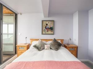 una camera con un letto bianco con due comodini di Four The Quay a Benllech