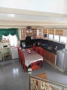 una cocina con mesa con sillas rojas y una cocina con en Room in Lobo Triple N Homestay 3rd N, 